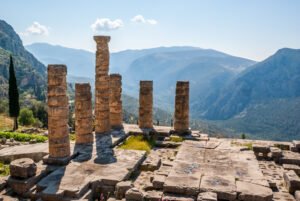 Ruins and columns of an ancient greek temple in front of the surrounding mountains